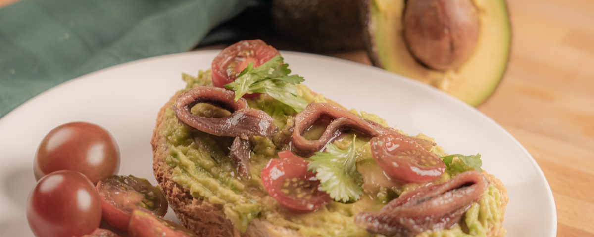 Recetas de tostas para cenar: Tosta de guacamole, tomate y anchoas