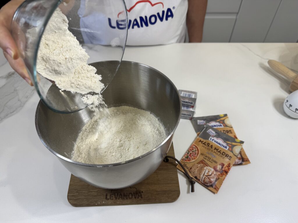 Vertiendo harina en un bol para hacer la masa de la coca