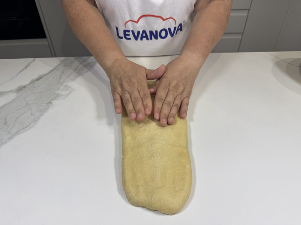 Dando forma alargada a la masa sobre la mesa
