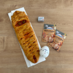 Pizza de Halloween con forma de momia, decorada con aceitunas como ojos y acompañada de productos de masa madre Levanova